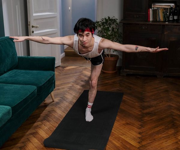 Man holding a difficult balance pose with focus.